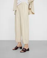 Pantalón barrel fit de cuero sintético color beige, con cintura elástica y bolsillos laterales.