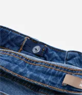 Bermuda ciclista de jean azul de tiro alto con terminación deshilachada.