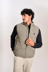 Chaleco puffer de corte regular, color beige, con cierre frontal y cuello alto. Presenta un diseño acolchado horizontal y logo bordado en el pecho.