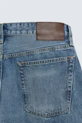Jeans de denim de algodón, tiro medio, con corte barrel fit amplio en cadera y muslos que se estrecha hacia el tobillo. Presenta efecto lavado y cierre frontal con botones.
