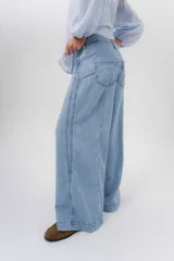 Jean de tiro medio con diseño de pierna amplia y corte holgado, confeccionado en denim azul. Cuenta con bolsillos delanteros y traseros funcionales.