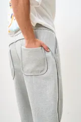 Pantalón de jogging gris con cintura elástica y cordón ajustable.