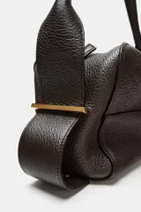 Bolso alargado de piel color marrón oscuro, con asa de hombro y cierre de cremallera. Incluye cartera con bolsillo extraíble.