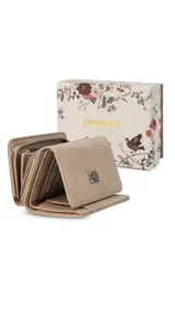 Billetera corta de símil cuero color beige, con cierre a presión y placa metálica decorativa. Cuenta con múltiples compartimentos internos para tarjetas, visor y billetes, además de un compartimento posterior con cierre.