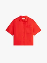 Camisa de manga corta de corte amplio color rojo, confeccionada en puro lino. Cuenta con cuello inglés, bolsillo de parche en el pecho con logo bordado y hombros ligeramente caídos.