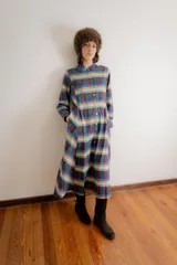 Vestido midi de corte camisero con cuello redondo, cierre frontal de botones y mangas largas. Confeccionado en popelina de algodón con un diseño de estampado a cuadros multicolor en disposición vertical y diagonal.