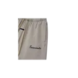 Short de felpa Fear of God Essentials, color gris, con cintura elástica con cordón ajustable largo, bolsillos laterales y el texto "Essentials" bordado en la pierna izquierda.
