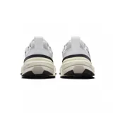 Championes Nike V2K Run de estilo retro-futurista, con diseño en capas de malla y material sintético en tonos beige y gris. Presenta una entresuela robusta con tecnología Cushlon y el logo de Nike en el lateral.