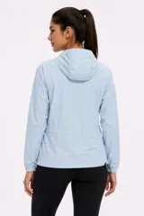 Campera cortaviento celeste con capucha ajustable, cierre frontal y bolsillos laterales con cierres negros contrastantes.