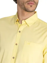 Camisa casual RKF Galiton para hombre, color amarillo claro, de manga larga ajustable con botones de madera y bolsillo en el pecho con logo bordado. Confeccionada en popelina 100% algodón orgánico con protección UV 20+.
