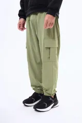 Pantalon cargo negro de corte holgado, con bolsillos laterales con solapa y puños elásticos en los tobillos. Cuenta con cintura elástica con cordón de ajuste.