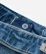 Pantalón de jean skinny azul con deshilachados, tiro alto y ajuste elástico en la cintura. Confeccionado en algodón BCI.