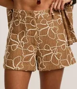 Short color marrón con estampado abstracto en blanco, texturizado, con trabillas en la cintura y cierre tradicional.