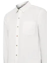 Camisa de manga larga color blanco, confeccionada en popelina de algodón orgánico. Presenta cuello camisero, cierre frontal con botones de madera, un bolsillo en el pecho y mangas ajustables con botones.