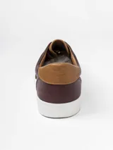 Champion de estilo urbano en color azul marino, con detalles en cuero sintético color suela en la lengüeta y el talón. Presenta perforaciones decorativas en los laterales y suela de goma blanca.