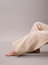 Pantalón chino de Calvin Klein, color beige, con diseño de pierna súper ancha, tiro alto, cinco bolsillos y cierre frontal con botón y cremallera.