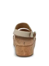 Sandalias de plataforma con suela de corcho y capellada combinada de cuero marrón y tira de tela beige en el empeine. Cuenta con tira trasera ajustable con hebilla metálica y detalles en cuero marrón.