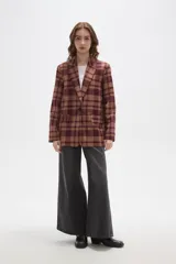 Blazer de corte holgado con diseño a cuadros en tonos marrones y negros. Presenta cuello con solapa, cierre frontal con un botón y bolsillos laterales con solapa.