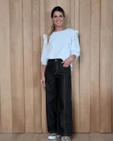 Jean de corte ancho y tiro medio, confeccionado en denim 100% algodón. Presenta costuras verticales decorativas en el frente y ruedo desflecado.