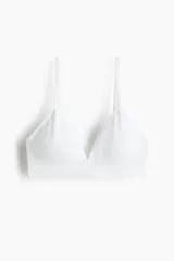 Soutien suave sin costuras, color blanco, con diseño de punto acanalado, copas triangulares con relleno removible y tirantes finos ajustables.
