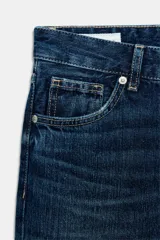 Jeans wide leg de tiro bajo y cinco bolsillos con efecto lavado y cierre frontal con cremallera y botón metálico.