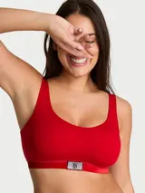 Bralette sin aros color rojo, con copas ligeramente forradas, escote redondo y banda de terciopelo con parche brillante de diamantes de imitación con logo en el centro.