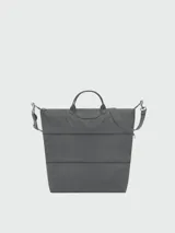 Bolso de viaje Longchamp modelo Le Pliage One, de diseño minimalista y funcional en color azul grisáceo. Cuenta con asas cortas, correa ajustable para el hombro y cierre superior con solapa de botón a presión.