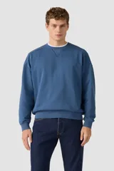 Buzo azul de cuello redondo con detalle de costura triangular en el escote, mangas largas y ajuste acanalado en puños y cintura.