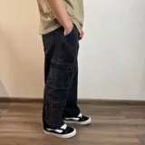 Jean cargo de corte baggy en color azul lavado, con múltiples bolsillos laterales tipo cargo y cierre frontal.