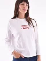 Remera de manga larga color beige, con cuello redondo y estampado frontal que dice "Magic is something you make" en color lila.