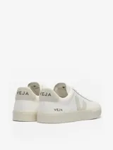 Championes Veja modelo Campo, de diseño minimalista en color blanco con detalles en ante gris claro. Presentan el logo de la marca en el lateral, cierre con cordones y suela de goma en tono crema.