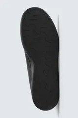 Zapatilla tipo botín de estilo minimalista fabricada en piel lisa de color negro. Presenta un diseño de caña media con cierre de cordones al tono y suela plana de goma a juego.