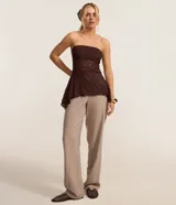 Blusa strapless de encaje negro con escote recto y dobladillo asimétrico con puntas diferenciadas.