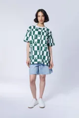 Remera de manga corta con estampado de cuadros verdes y blancos, con pequeños motivos de la silueta de Mickey Mouse dispersos por el diseño.