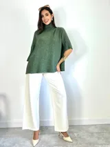 Poleron de punto color beige, con cuello alto y mangas tres cuartos con puños acanalados. Diseño holgado y oversized.