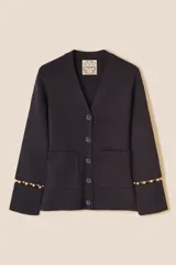 Cárdigan de punto color azul marino, con escote en V, cierre frontal con botones al tono y bolsillos de parche. Presenta mangas largas con aberturas decoradas con cuentas doradas en los puños.