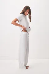 Pantalón gris melange de pernera ancha, tiro medio, con cintura elástica y cordón ajustable.