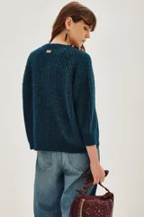 Cardigan de punto grueso acanalado color azul, con cuello redondo, cierre frontal de botones y mangas largas.