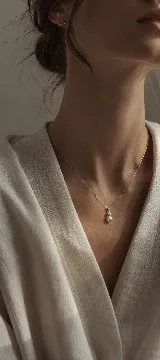 Colgante de plata 925 rodinada con cadena fina, que presenta un dije compuesto por una perla natural de río y una circonia cúbica brillante.
