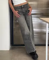 Pantalón de jean gris con efecto lavado, de corte recto y tiro bajo. Presenta costuras verticales decorativas en el frente y bolsillos tipo cargo frontales.