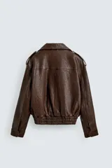 Cazadora biker de corte oversize confeccionada en piel color marrón. Presenta cuello con solapas de pico, cierre frontal asimétrico con cremallera, bolsillos laterales de vivo y bajo con elástico. Las mangas largas cuentan con puños ajustables con cremallera.