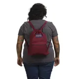Mochila JanSport color bordó, tipo bolso con cordón ajustable y bolsillo frontal con cierre.