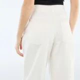Pantalón de jean con corte globo, tiro alto y diseño de pierna ancha. Presenta cierre frontal con botón y bolsillos laterales.