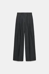 Pantalón de tiro medio con diseño de pierna ancha y pinzas frontales. Cuenta con cintura con trabillas, bolsillos laterales ocultos y cierre frontal con cremallera, botón y ganchos metálicos.