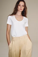 Camiseta de algodón con corte regular, escote redondo amplio y manga corta. Presenta un diseño básico con bajo recto.