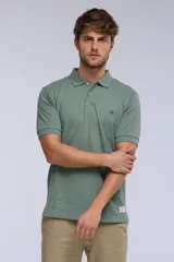 Remera polo de manga corta en tejido piqué color celeste. Presenta cuello clásico con botones, bordado pequeño en el pecho y detalles en tela oxford en el interior del cuello.