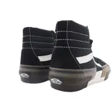 Championes Vans modelo Sk8-Hi Rearrange, de caña alta, con diseño deconstruido en la suela. Presenta una combinación de colores negro, blanco, marrón y verde oliva, con la icónica banda lateral blanca y cierre de cordones.
