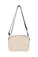 Bandolera de diseño compacto en color beige, con compartimento principal y bolsillo frontal, ambos con cierre. Incluye correa larga regulable y detalle de tirador con cordón en el cierre frontal.