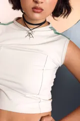 Top corto de color crudo con diseño ajustado, cuello redondo y detalle de franjas laterales en color verde. Presenta costuras visibles que definen la estructura de la prenda.