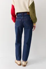 Pantalón de jean azul oscuro, corte mom, con pespuntes rojos y confeccionado en 100% algodón.
